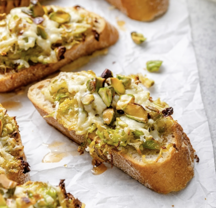 White Cheddar Brussels Sprouts & Pistachio Crostini with Hot Honey